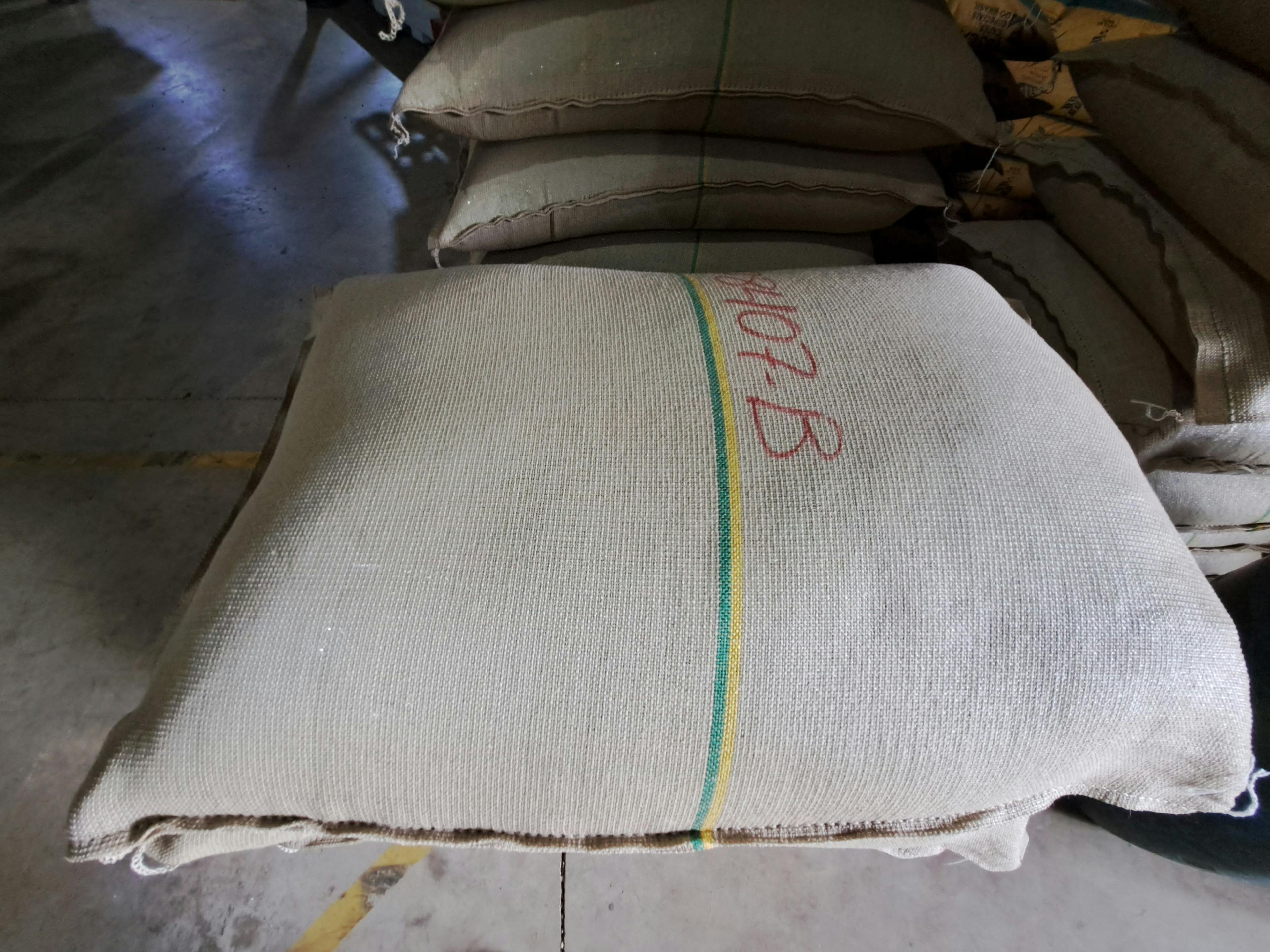 a pile of bags stacked on top of each other in a warehouse .