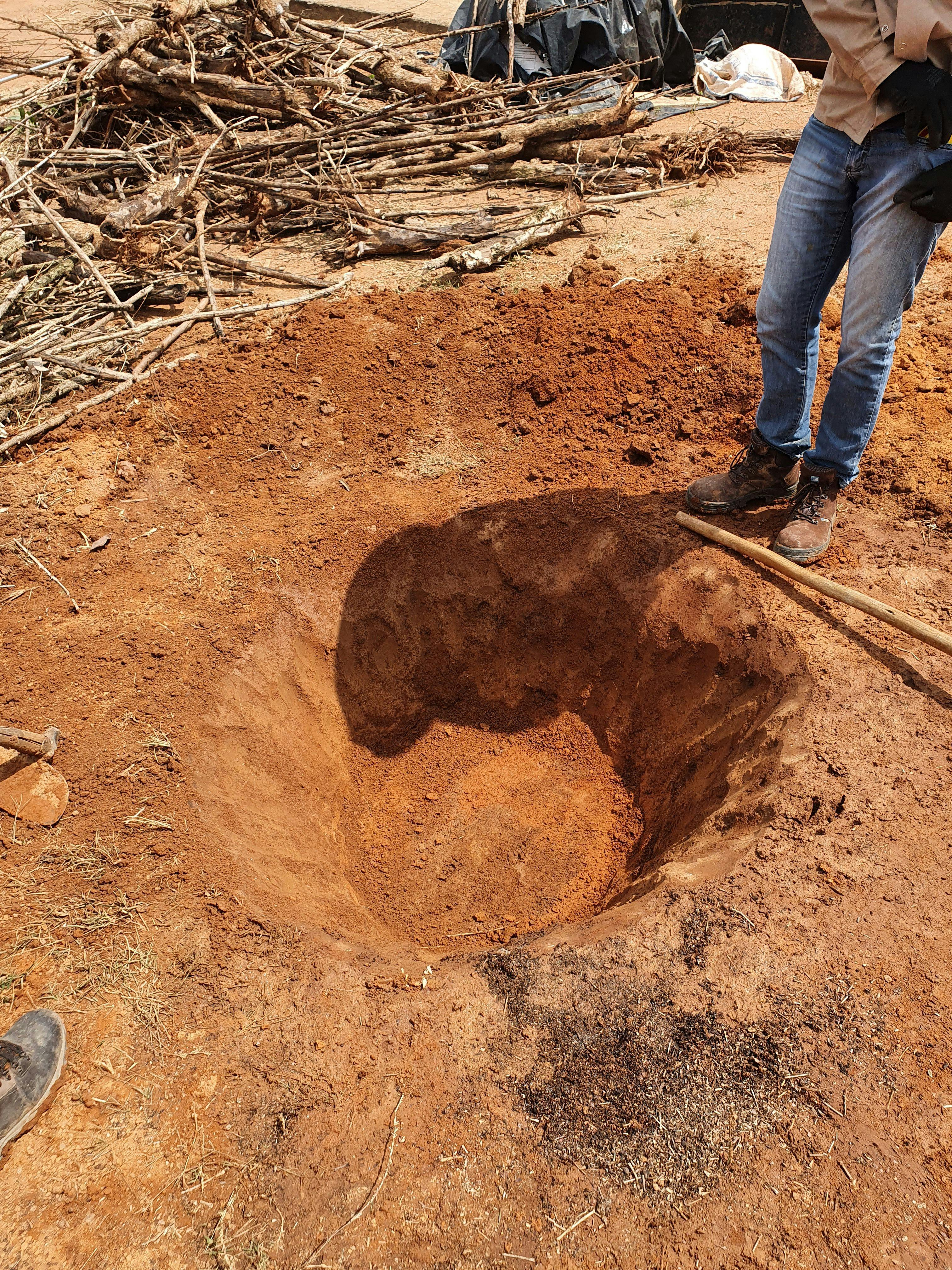 a man is digging a hole in the dirt with a shovel