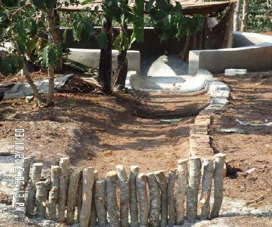 there is a fence made of logs in the middle of the dirt .