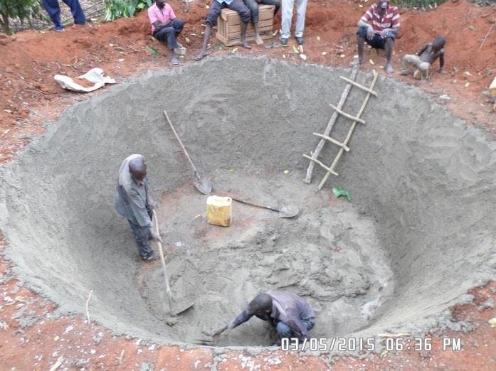 a group of people are working on a large hole in the ground .