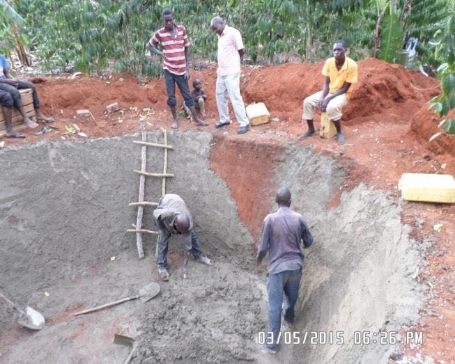 People plastering the wall of excavated pit