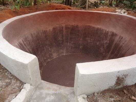 a large circular hole in the ground with a concrete wall around it .