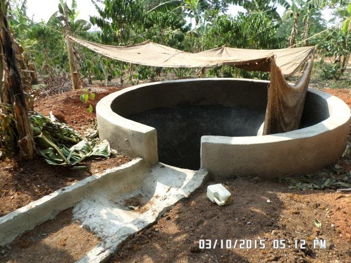 a large concrete circular structure is being built in the dirt .