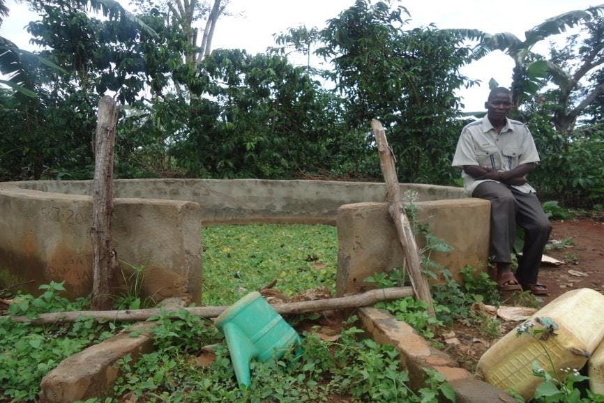 a man is sitting on a rock next to a water tank .