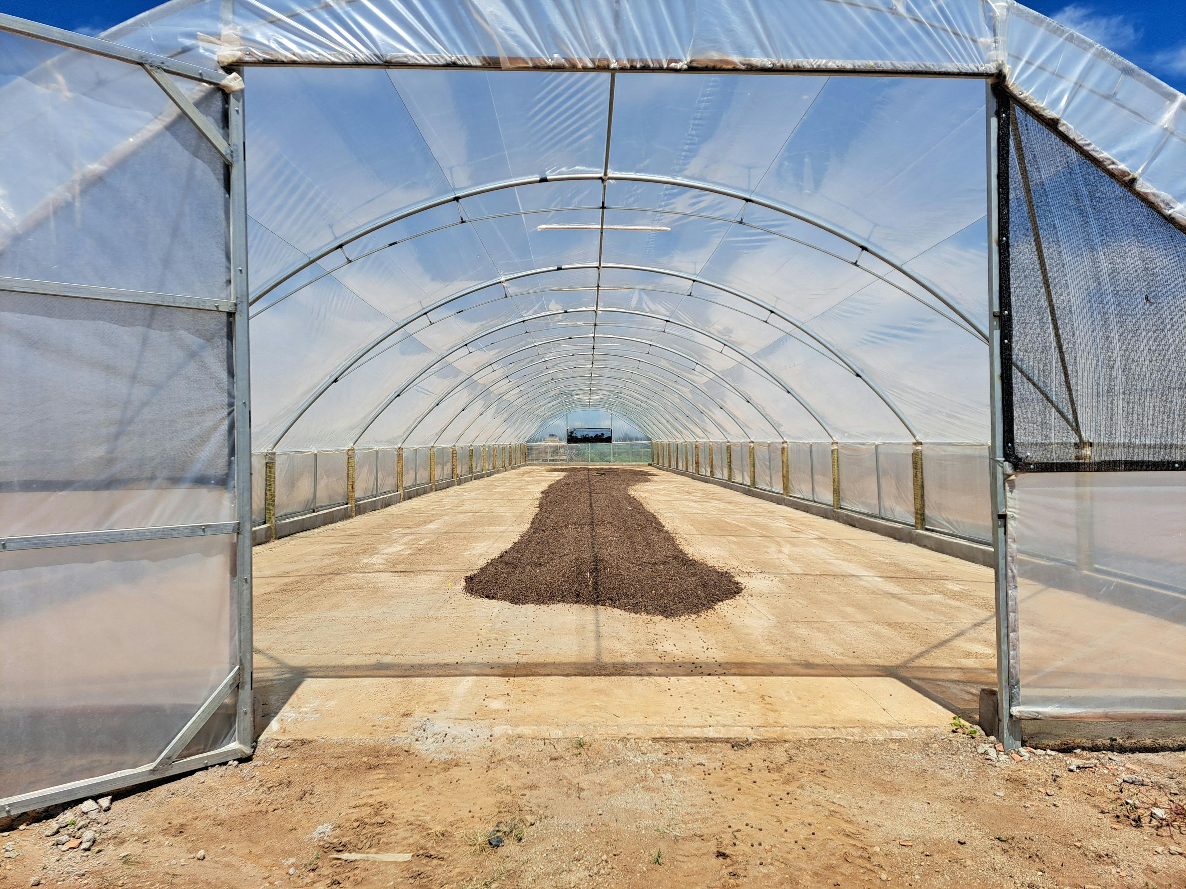 a greenhouse with a lot of soil inside of it .