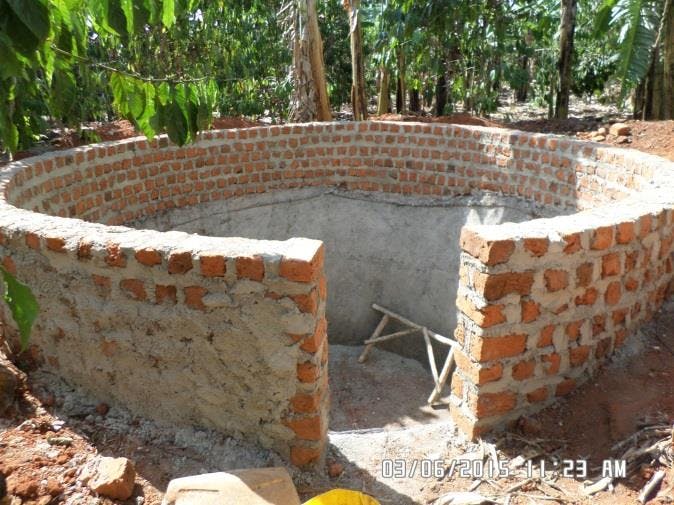 a large brick wall is being built in the middle of a field .